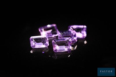 three purple amethtites sitting on top of a black surface