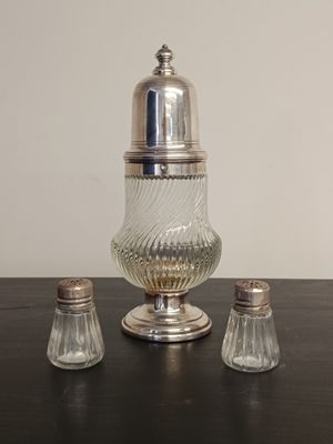 un ensemble de salière et poivrière en verre posé sur une table