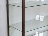 a glass display case on a wooden shelf in a room