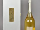 bottle of champagne in front of a white box with a gold label