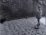 black and white photograph of a little boy walking down a cobblestone street