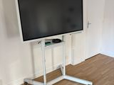 un téléviseur à écran plat posé sur un support dans le coin d'une pièce