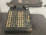 an old typewriter sitting on top of a table next to a brick wall