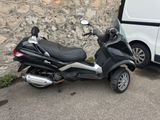 a scooter parked next to a van in a parking lot
