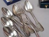 a lot of silver spoons and spoons on a table