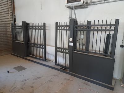 two black gates in a room with a toilet in it