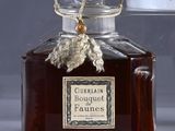 a bottle of perfume sitting on a table next to a cup