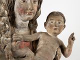 une statue ancienne d'une femme tenant un enfant dans ses bras
