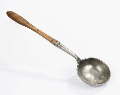 an old spoon with a wooden handle on a white surface