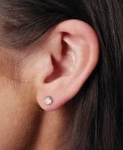 un gros plan sur l'oreille d'une femme portant une paire de boucles d'oreilles