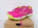 pink and yellow tennis shoes in a box on a white surface
