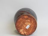 an image of a brown and black vase sitting on top of a white surface
