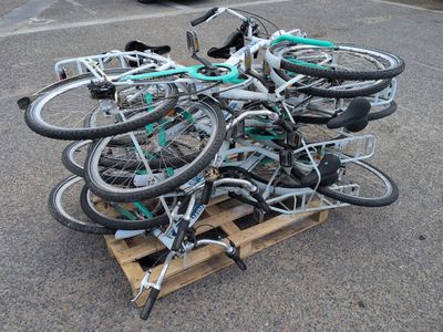 many bikes that are sitting on a pallet in the parking lot