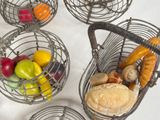 four metal baskets with different types of food in them on a table