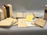 several old books are sitting on a table with a white background