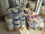 a pallet full of buckets of paint next to a pallet full of buckets of paint