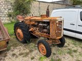 un vieux tracteur qui est à l'abandon dans l'herbe