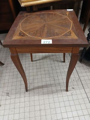 a small table with a wooden top on a tile floor