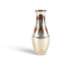 un vase en argent posé sur une surface blanche