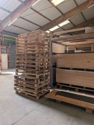 many pallets of wood stacked up in a warehouse