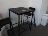 a small table and two stools in the corner of a room