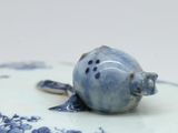 a close up of a blue and white plate with a bird on it
