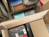 a box full of books sitting on the floor next to a pile of other books