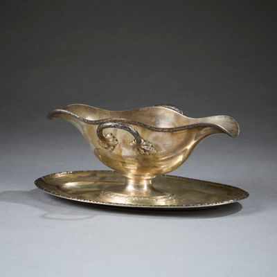 un service en argent ancien composé d'une assiette et d'une soucoupe posée dessus