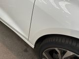 a white car parked in a parking lot with its door open