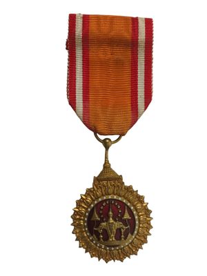 un gros plan d'une médaille sur fond blanc, avec un ruban rouge