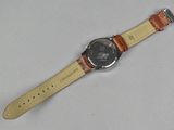 wrist watch with brown leather strap on a white surface