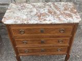 an old dresser with a marble top sits in front of a brick wall