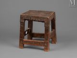 an old wooden stool with a wooden seat on a gray background