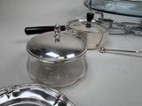 silver pots and pans sitting on a white counter top next to a toaster and a toaster