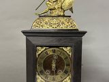 a clock that has a statue on top of it