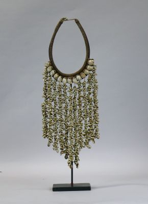 an image of a necklace made out of shells on a stand