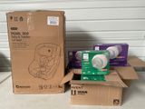 deux cartons de sièges auto pour bébés et un carton de lingettes posés sur une table