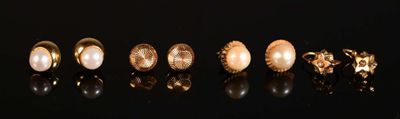 five pairs of gold and pearl rings on a black surface