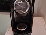 a coffee maker sitting on a white shelf next to a window