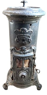 Poêle ancien en métal noirci, socle avec des pieds sculptés …