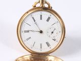 a gold pocket watch with roman numerals on it