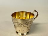 a silver cup with a handle and handles on a white surface