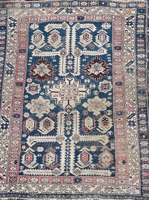an antique persian rug with a blue and red design