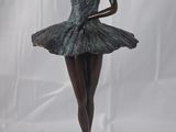 statue d'une ballerine sur un socle noir, avec un fond blanc
