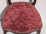 a chair with a red velvet seat and a wooden frame