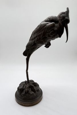 bronze statue of a bird on a pedestal on a white background