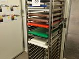 many trays of food on a metal rack in the kitchen
