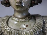un gros plan sur une figurine représentant une femme en robe