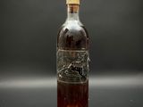 une vieille bouteille d'alcool sur laquelle est gravé un cheval