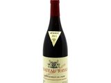 a bottle of red wine sitting on top of a white table